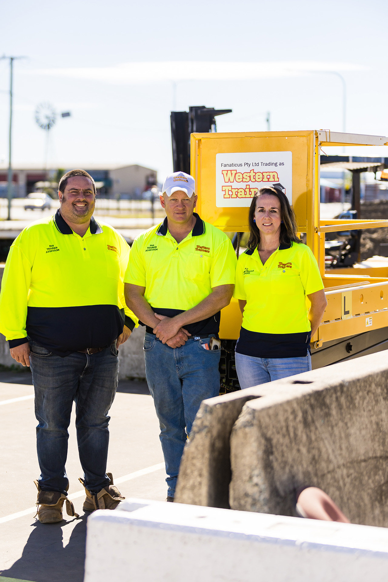 Three Western Trainers trainers stand together in front of a scissor lift